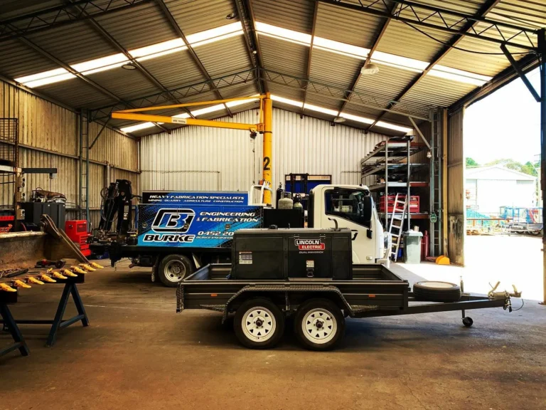 Fabrication workshop with truck and welding equipment.