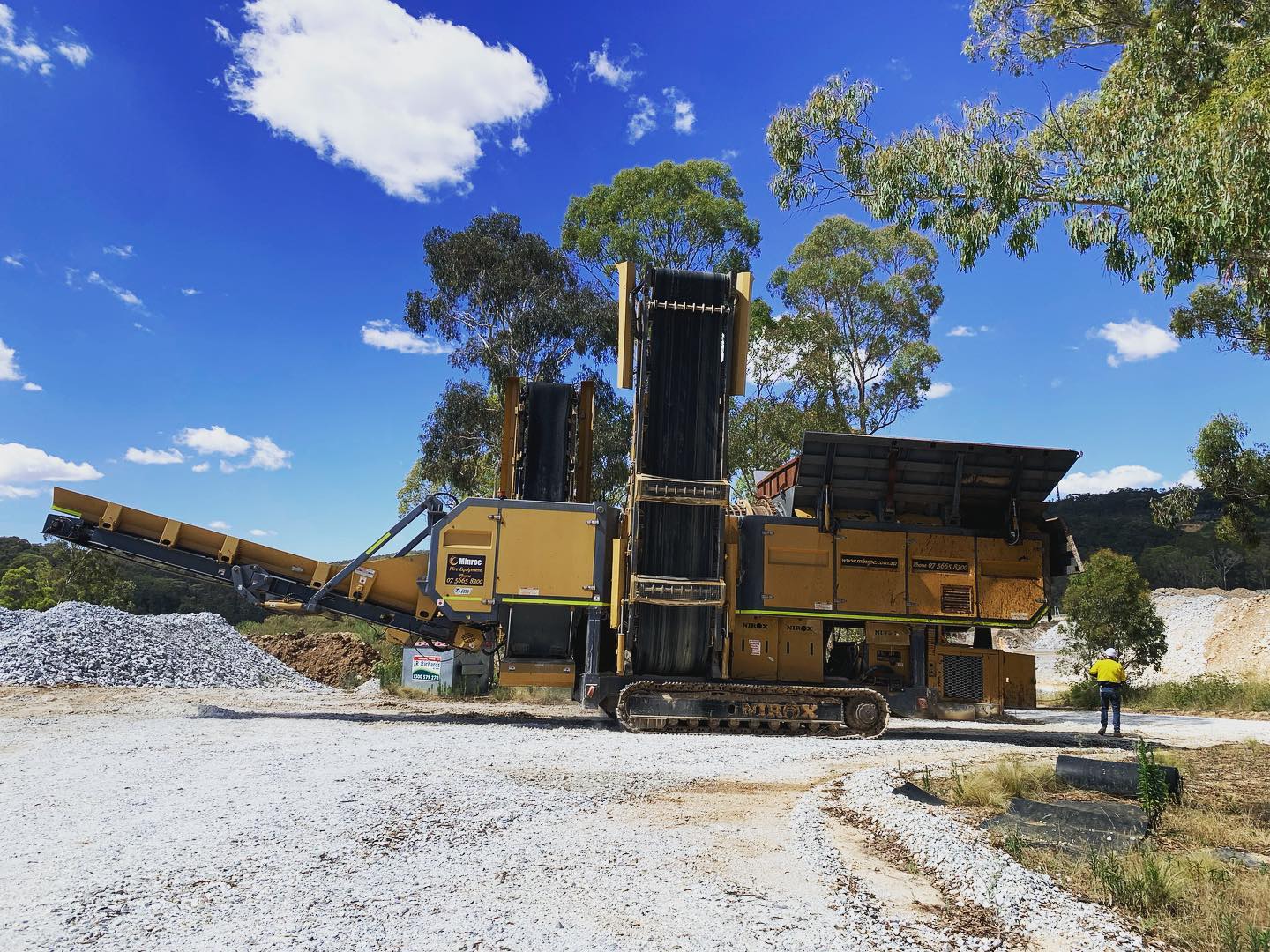 Large machinery crushing stone outdoors.