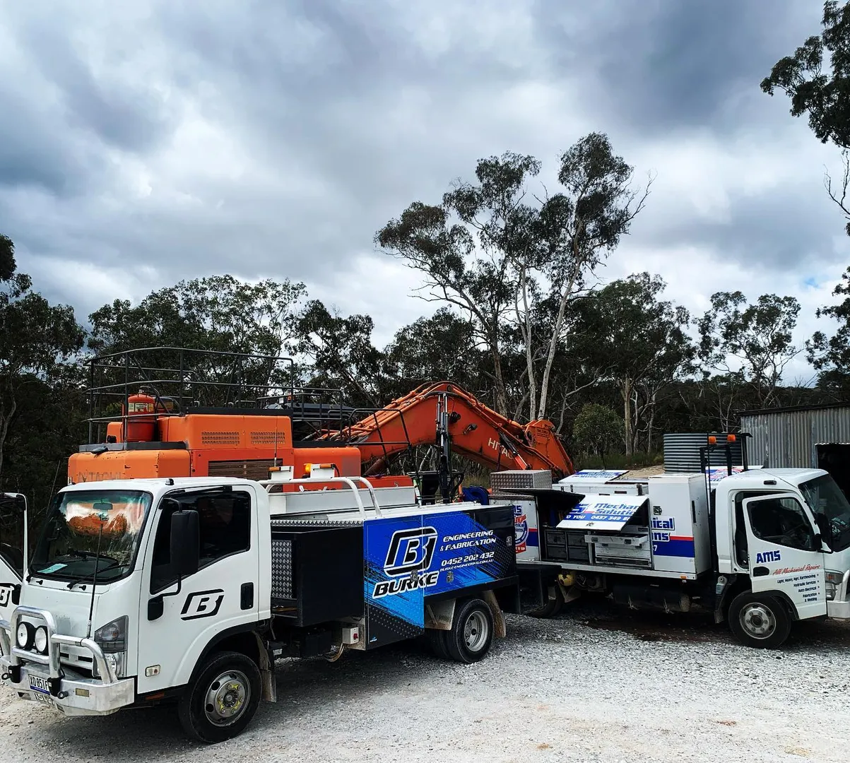 Burke and AMS trucks with an orange excavator.
