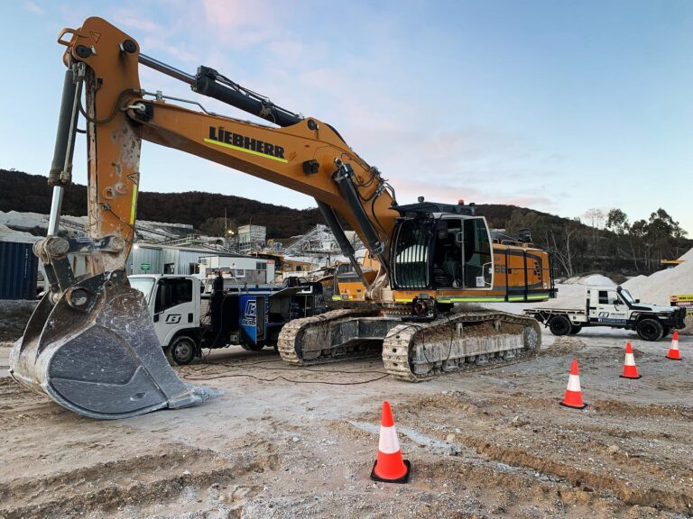 Large excavator at construction site with traffic cones.