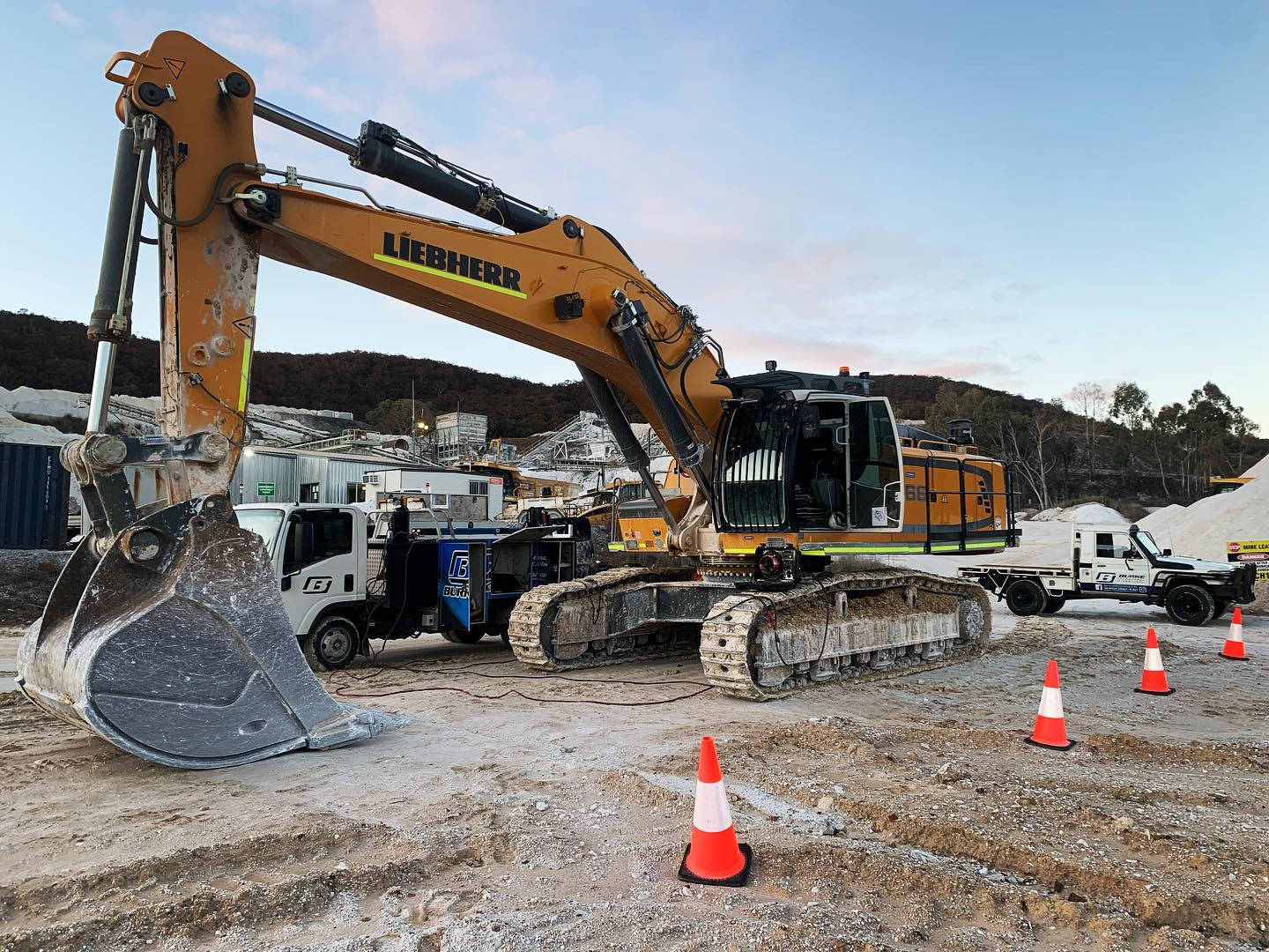Large excavator at construction site with traffic cones.